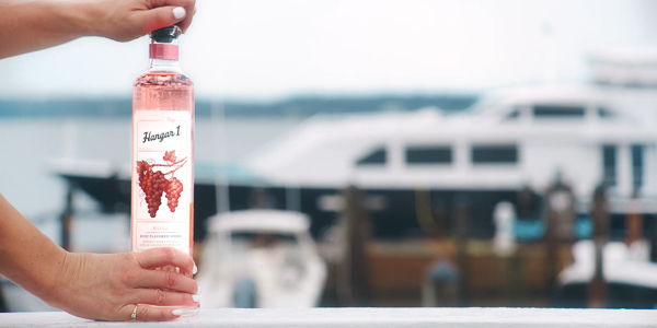 hands opening bottle of Hanger 1 rose vodka