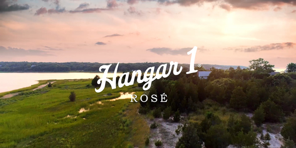 sunset landscape over the ocean, "hangar 1 rose" label centered
