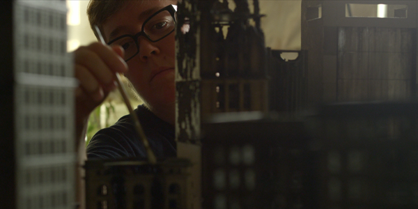 artist lori nix painting a model of a skyscraper